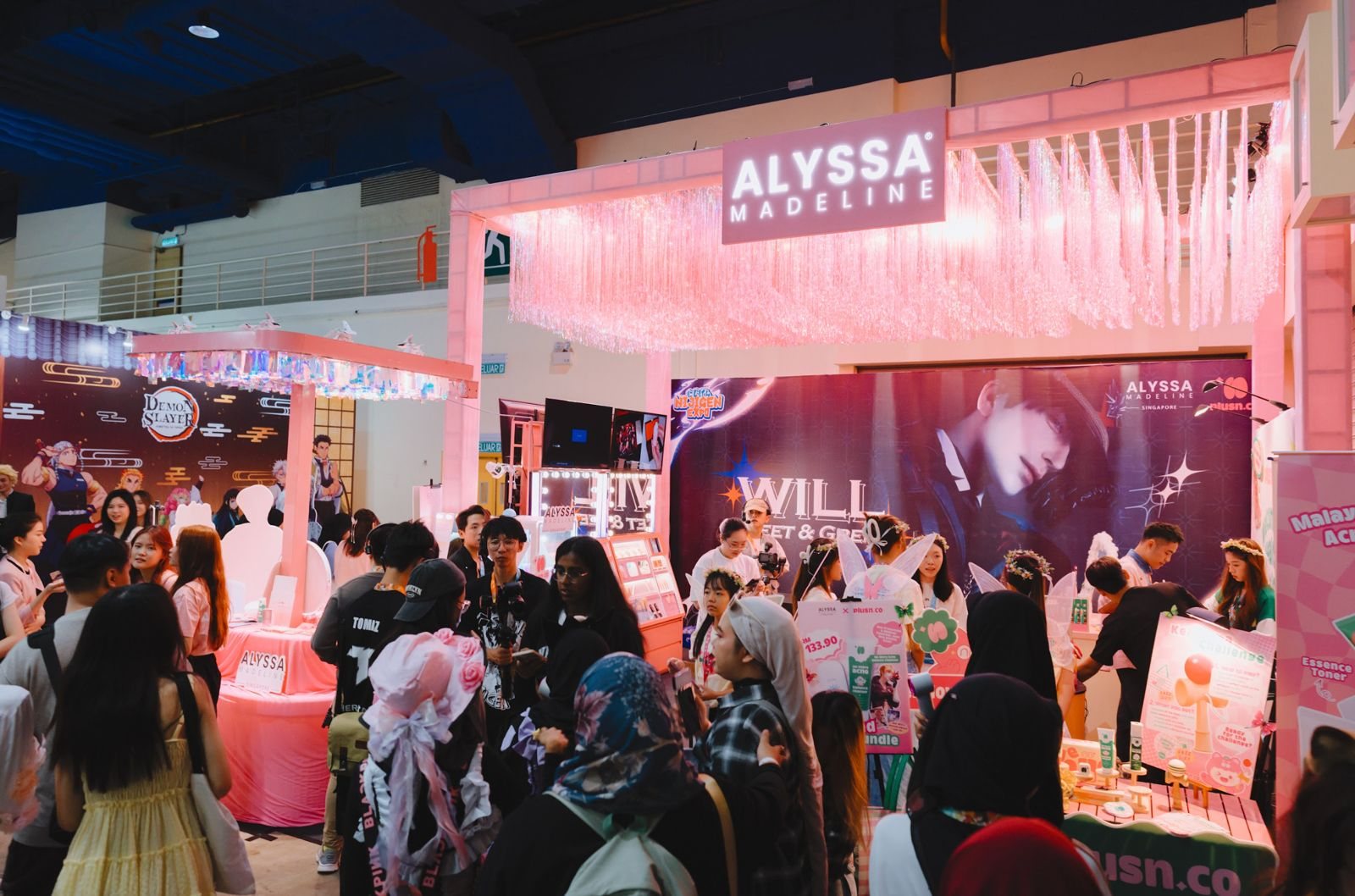 Pink branded event booth with attendees